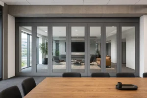 Completed boardroom with a framed movable glass wall aligned beneath a structural ceiling beam