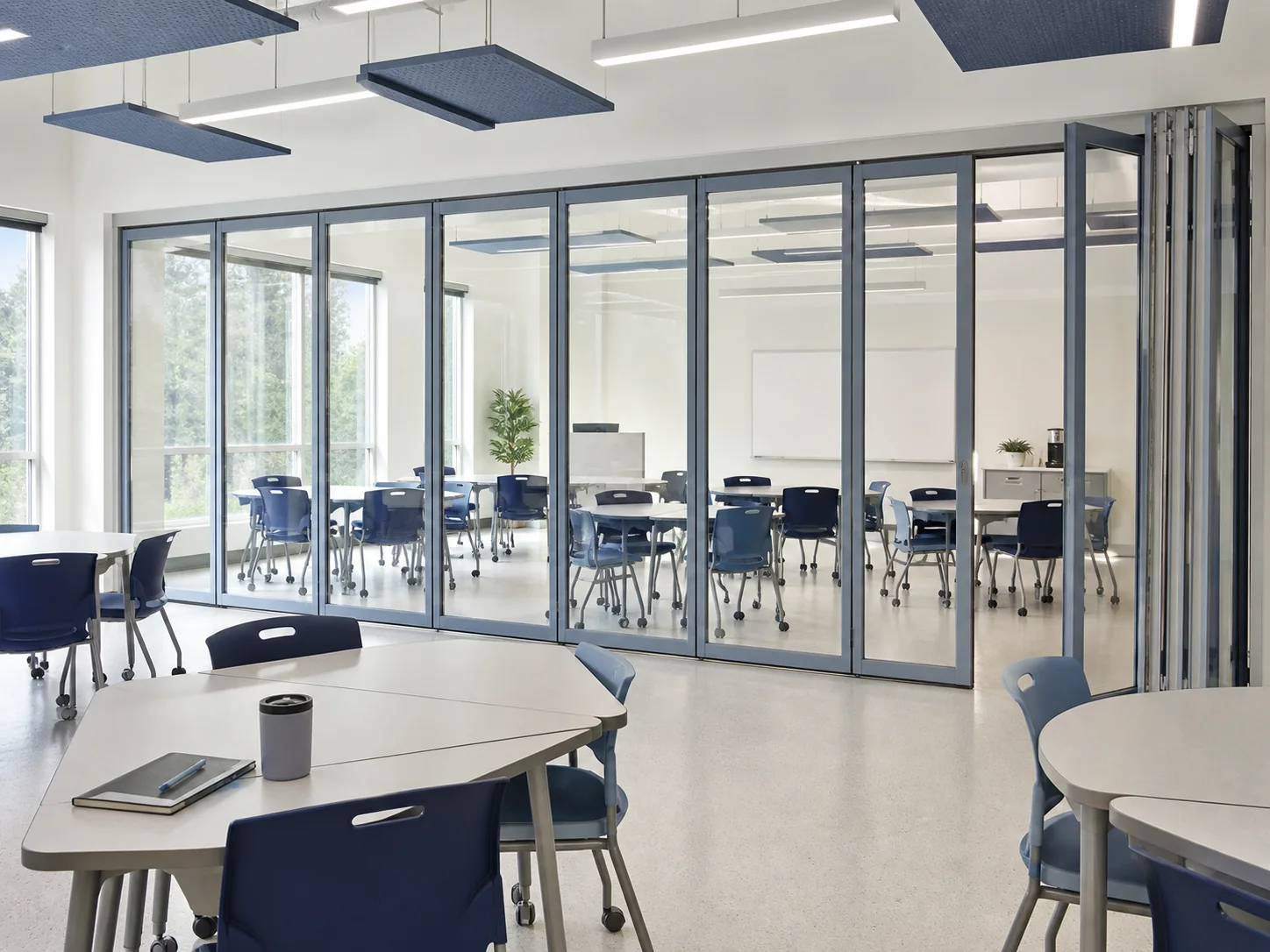 Framed movable glass partition dividing flexible adult training rooms